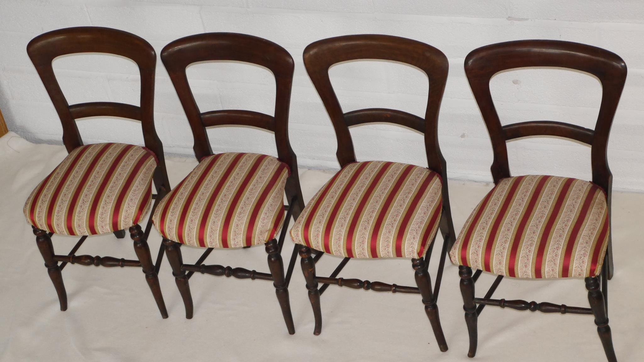 4 wooden chairs with red, gold and floral covers on side view